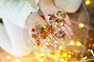 Golden stars sparkling on child`s hands and palms