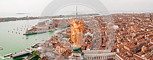 Golden statue of angel on top of clock tower in St Mark`s Square