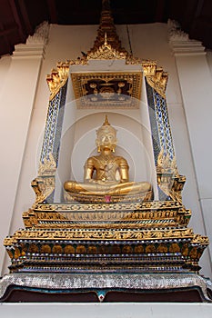 A golden statue of Buddha was installed in a niche hollowed out of one of the walls of Wat Na Phra Men in Ayutthaya (Thailand)