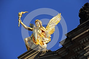 Golden statue of Eros against a blue sky in Dresden, Saxony, Germany