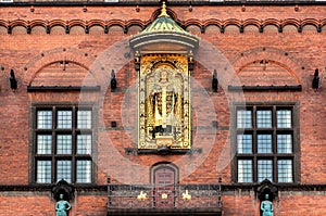 Golden statue on facade of historical Copenhagen City Hall, built in 1905 in Denmark. National Romantic style