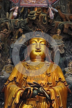 Golden Statue of Guanyin and Sudhana acompanied by their masters from the Jade Buddha Temple interior in Shanghai