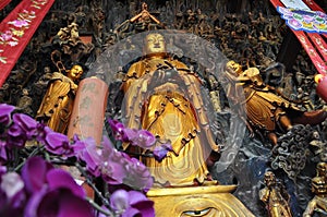 Golden Statue of Guanyin and Sudhana acompanied by their masters from the Jade Buddha Temple interior in Shanghai