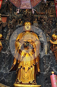 Golden Statue of Guanyin and Sudhana acompanied by their masters from the Jade Buddha Temple interior in Shanghai