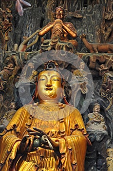 Golden Statue of Guanyin and Sudhana acompanied by their masters from the Jade Buddha Temple interior in Shanghai