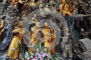 Golden Statue of Guanyin and Sudhana acompanied by their masters from the Jade Buddha Temple interior in Shanghai