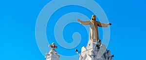 Golden Statue of Jesus Christ on the facade of the Temple of the Sacred Heart of Jesus, Barcelona, Catalonia, Spain. Isolated on