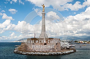 Golden statue of the `Madonna della Lettera` on an obelisk at the entrance of the harbor of Messina Sicily