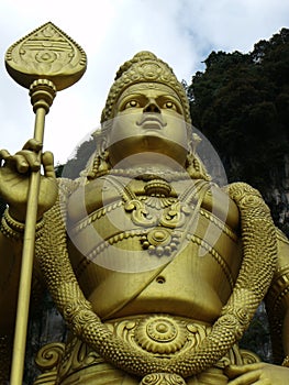 Golden statue of Murugan at the base of the Batu Caves stairs. Malaysia