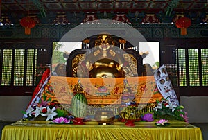 Golden Statue and offerings in Traditional Chinese Buddhist temple in Lumbini, Nepal