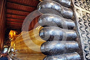 Golden statue of the reclining buddha in Bangkok, Thailand