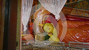 Golden statues of Buddha recline, sit in ornate robes, vibrant Buddhist temple, surrounded by intricate murals, white