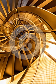 The golden steel staircase in spiral shape inside old building