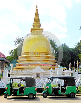 Golden stupa and two tuk tuks