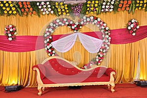 Golden style Indian stage decoration with multi color flowers, props and lights