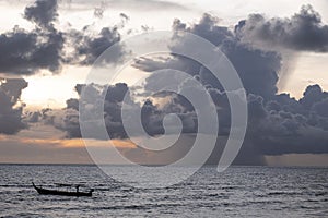 Golden sun light sunset in sea behind island. silhouette fisherman boat.gray cloud and rainy fall seascape