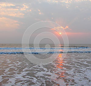 Golden Sun, Sunrays through Clouds and Reflection in Sea water - Payyambalam Beach, Kannur, Kerala, India