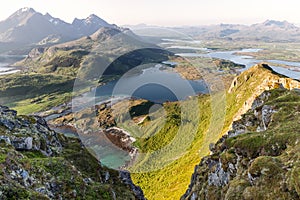 Golden sunlight bathes the verdant valleys and turquoise inlets of the Lofoten Islands, Norway