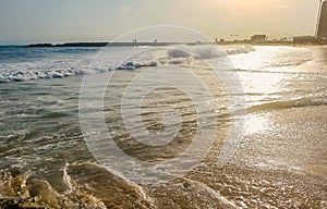 Golden sunlight reflecting on a beach in Lagos, Nigeria. Sun shining in the evening - waves breaking on the shore