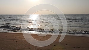 Golden sunlight reflecting on a beach. Sun shining in the evening - waves breaking on the shore. golden sunlight at beach.