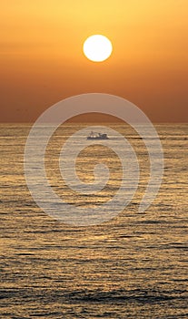 Golden sunrise in marbella, southern Spain with ocean and boat
