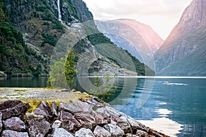 Golden sunrise in the mountains, Gudvangen Norway with reflection in the water of the fjord.