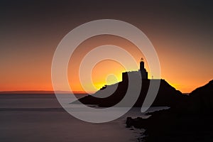 Golden sunrise over Mumbles lighthouse