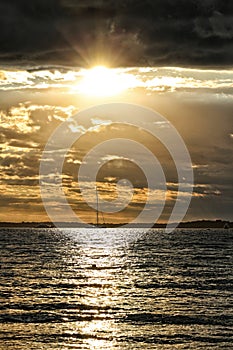 Golden sunset above the sea coast with clouds