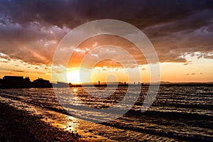 Golden sunset on the beach, over which hung a big cloud