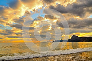Golden sunset on the Black sea coast in Crimea, sea wave.