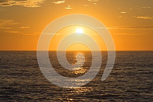Golden sunset centered over empty ocean