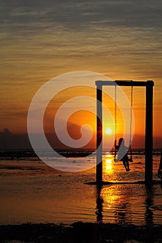 Golden sunset with enjoy swing in the beach