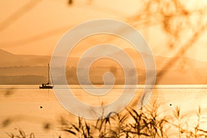 Golden sunset on a lake with a little boat