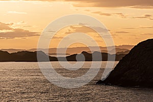 Golden sunset over an archipelago with wind turbines in the horizon