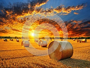 Golden sunset over farm field with hay bales, AI generated