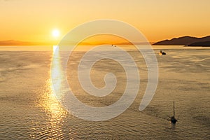 Golden Sunset into the sea with the silhouette of ship