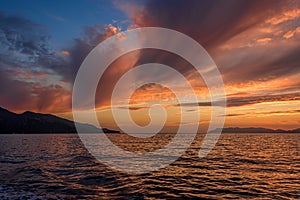 Golden sunset on the sea after storm with dark clouds