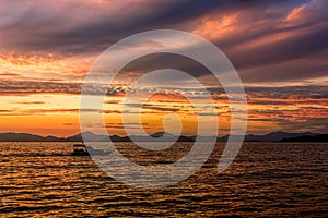 Golden sunset on the sea after storm with dark clouds