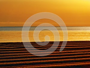 Golden sunset or sunrise on racked beach panorama. photo