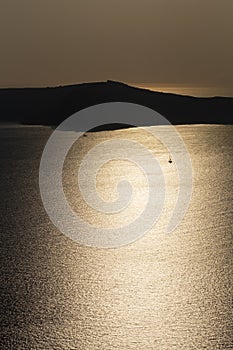 Golden sunset water landscape in the shore of Santorini Island, Greece