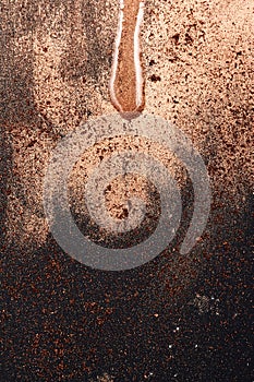 Golden Surface with flowing Drop of Oil