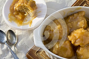 Golden Syrup Dumplings on Table with One portion on Plate photo