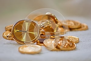 A golden table clock a bunch of gold coins