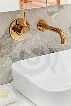 Golden tap in bathroom washbasin