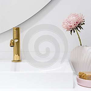 Golden tap in bathroom washbasin, close-up