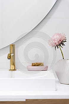 Golden tap in bathroom washbasin and cute decorations