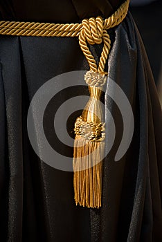 Golden tassel on black curtain