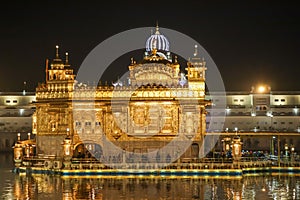 Golden temple with reflection in the water at night