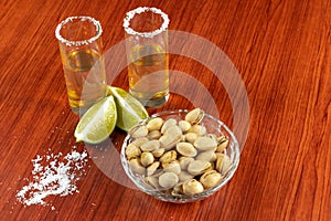 Golden tequila with lemon, pistachos, cacahuate, and salt. Drinks, Liquor photo