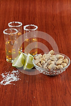 Golden tequila with lemon, pistachos, cacahuate, and salt. Drinks, Liquor photo